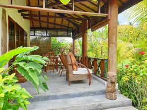 une terrasse couverte d'une maison avec des chaises et une table dans l'établissement Waiara Village Guesthouse, à Maumere