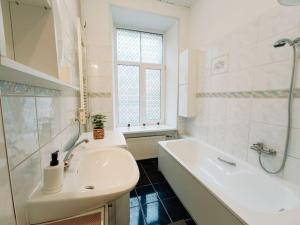 een witte badkamer met een bad en een wastafel bij Unique Spacious Classic 3 bedroom Midtown Apartment ! BILLIARD room ! in Rīga
