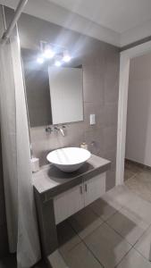 La salle de bains est pourvue d'un lavabo blanc et d'un miroir. dans l'établissement Orfila Apart 1, à Mendoza