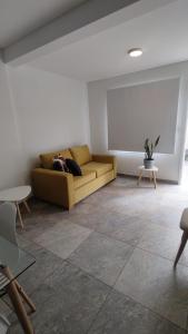 ein Wohnzimmer mit einem Sofa und einem Tisch in der Unterkunft Orfila Apart 1 in Mendoza