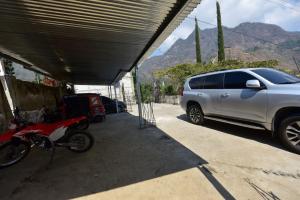 un SUV parcheggiato in un garage accanto a una moto di CASA EL ROBLE a San Juan La Laguna