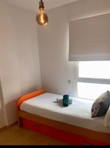 a small bedroom with a bed with a window at Light House in Corralejo