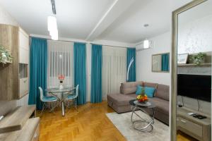 a living room with a couch and a table at Apartman SUNSET in Sremska Mitrovica