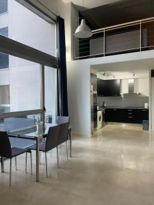 a dining room with a table and chairs and a kitchen at Apartamentos Marquesado in Madrid