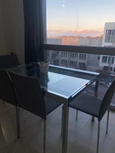 a glass table and chairs in a room with a window at Apartamentos Marquesado in Madrid