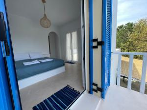 a bedroom with a bed and a balcony at The Velanidies - Οι Βελανιδιές in Agia Marina