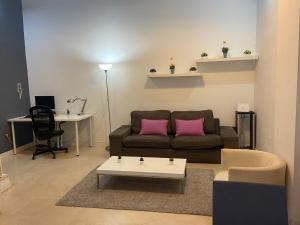 un soggiorno con divano e 2 cuscini rosa di Apartamentos Marquesado a Madrid