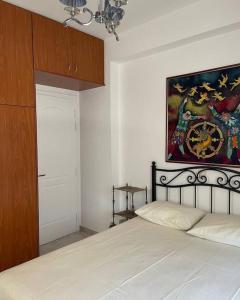 a bedroom with a bed and a painting on the wall at Villa Marina a breath away from the sea in Áyios Dhimítrios