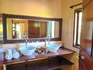 un baño con 2 cuencos en una encimera con espejo en Waiara Village Guesthouse, en Maumere
