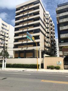 a street sign in front of a tall building at Beira-mar em Pajuçara com excelente localização in Maceió