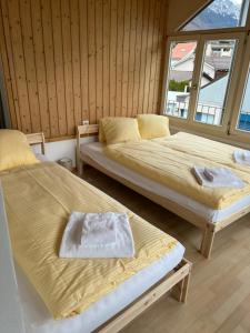 two beds sitting in a room with a window at Apartment CARMEN in Interlaken