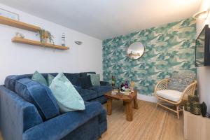 a living room with a blue couch and a table at Dream Achieved in St Ives