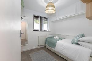 a white bedroom with a bed and a window at Dream Achieved in St Ives