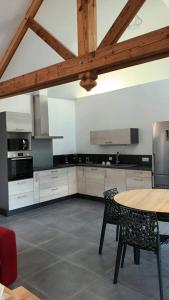 a kitchen with a table and chairs and a wooden ceiling at Le Loft in Barjac