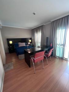 um quarto com uma secretária, cadeiras e uma cama em HOTEL PERDIZES - FLAT Executivo - 1403 em São Paulo