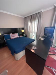 um quarto com uma cama e uma secretária com um computador portátil em HOTEL PERDIZES - FLAT Executivo - 1403 em São Paulo