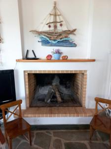 a living room with a fireplace with a boat on the wall at Villa Dimitra in Mourteri