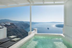 a swimming pool with a view of the ocean at Aqua Luxury Suites Santorini in Imerovigli