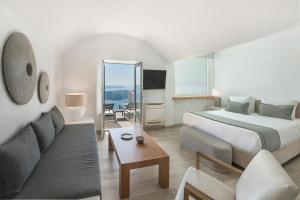 イメロヴィグリにあるアクア ラグジュアリー スイーツ サントリーニのベッドとソファ付きのホテルルーム