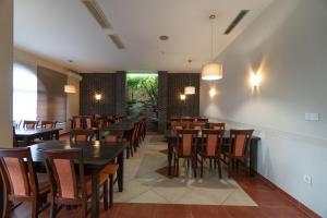 uma sala de jantar com mesas e cadeiras de madeira em Hotel & Restaurant Babic em Vranovača