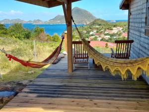 a hammock on a porch with a view of the ocean at TI KAZ ANOLI vue époustouflante sur la baie in Terre-de-Bas
