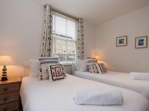 2 camas individuales en una habitación con ventana en Snugglers Cove Apt 2, en Dartmouth