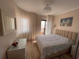 een kleine slaapkamer met een bed en een raam bij Costa de Caparica in Costa da Caparica