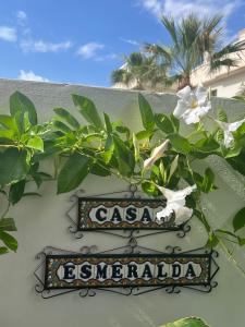 una señal en el lado de un edificio con flores en Casa Esmeralda - holiday apartment Costa Blanca, en Ciudad Quesada