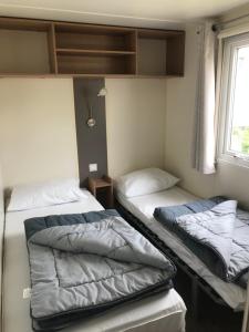 Llit o llits en una habitació de Camping Siblu domaine de Dugny