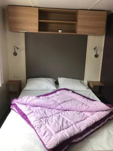 翁贊的住宿－Camping Siblu domaine de Dugny，床上有紫色毯子