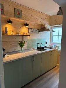eine Küche mit Holzwänden, einem Waschbecken und einer Theke in der Unterkunft RL Guesthouses in Geilenkirchen