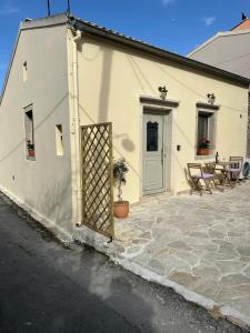 a white building with a gate and a patio at Casa dei Spinoula in Kanálion