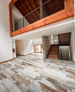 Habitación vacía con techo de madera y escalera en Patagonia Host, JAMA en Villa La Angostura