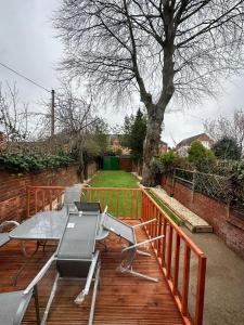 a barbecue grill on a wooden deck with a tree at Regent Luxury Studio in Coventry