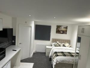 Habitación blanca con cama y TV en Regent Luxury Studio en Coventry