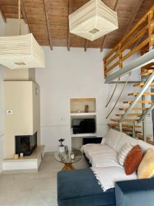 a living room with a blue couch and stairs at Casa dei Spinoula in Kanálion