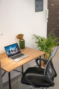 Lydia's Apartment في مدينة هيراكيلون: طاولة خشبية مع جهاز كمبيوتر محمول