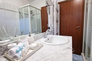 ein weißes Bad mit einem Waschbecken und einem WC in der Unterkunft MONZA CENTRO 5 Minuti POLICLINICO STADIO MONZA in Monza