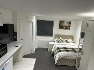 a bedroom with a bed and a desk and a television at Regent Luxury Studio in Coventry