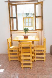 uma mesa e cadeiras de madeira com um vaso de plantas em Surfside BEACH FRONT CABANAS em Montañita