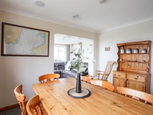 a living room with a wooden table with a vase on it at Pen Y Garth in Pwllheli