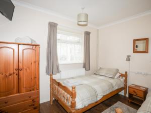 a bedroom with a bed and a window at Pen Y Garth in Pwllheli