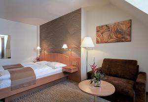 ein Hotelzimmer mit einem Bett und einem Stuhl in der Unterkunft Club Hotel Cortina in Wien