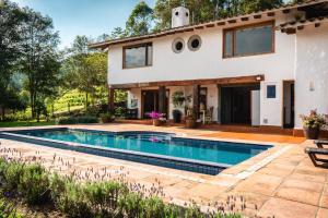 a villa with a swimming pool in front of a house at Finca La Hacienda in El Retiro