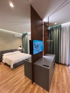 a bedroom with a bed and a flat screen tv at Bujtina Apsus in Berat