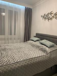 a bedroom with a bed with two pillows on it at Jurata Apartament Glamour in Jurata