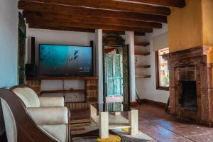 sala de estar con TV y chimenea en Finca La Hacienda en El Retiro