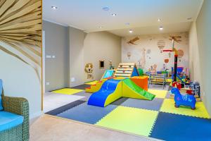 una sala de juegos para niños con un tobogán y un juego de juegos en Kashubian Resort en Władysławowo