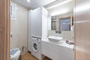 ein Badezimmer mit einem Waschbecken und einer Waschmaschine in der Unterkunft Lydia's Apartment in Iraklio