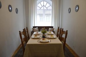 een eetkamer met een tafel met stoelen en een raam bij Unique Spacious Classic 3 bedroom Midtown Apartment ! BILLIARD room ! in Rīga